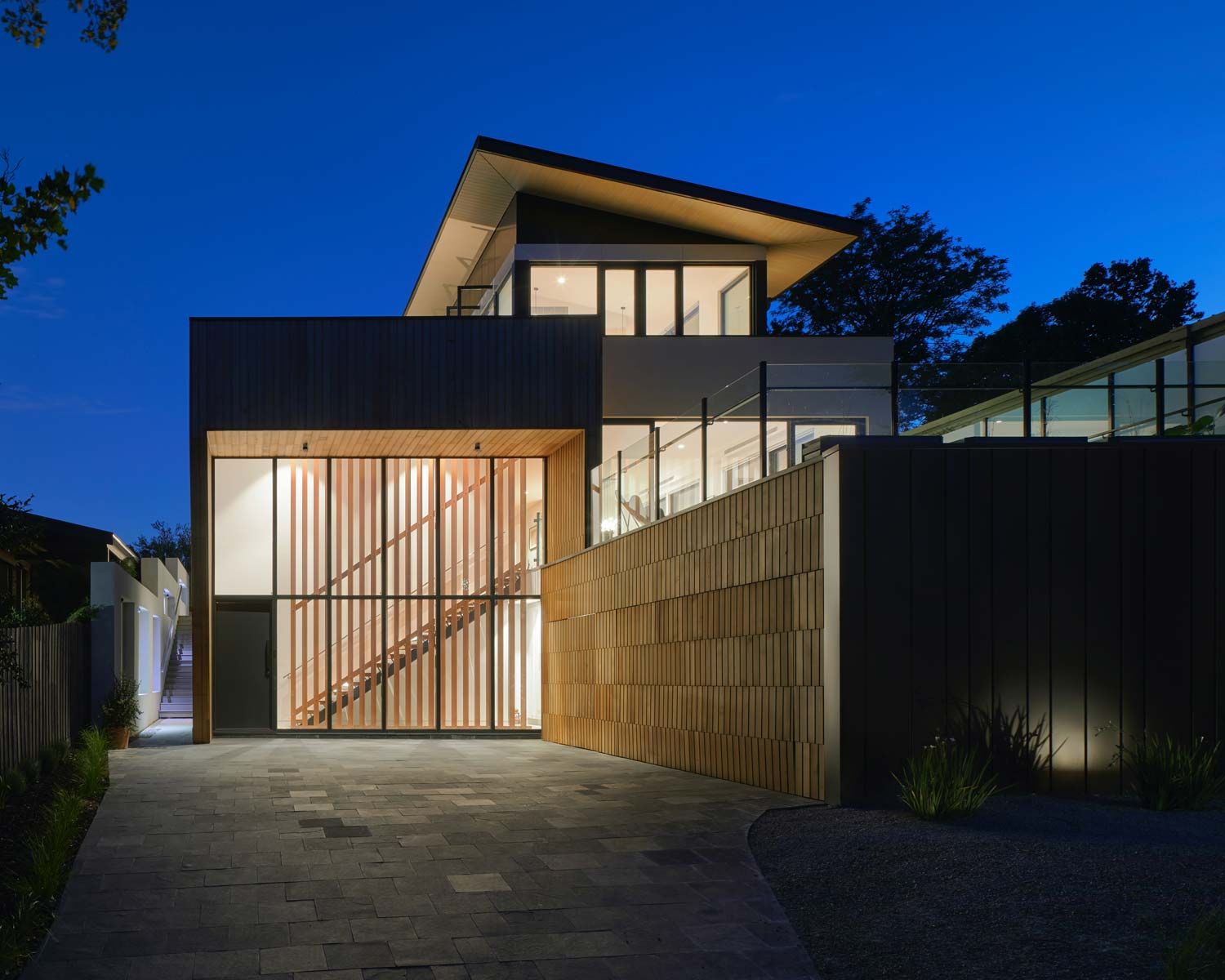 beautiful modern home lit up at dusk